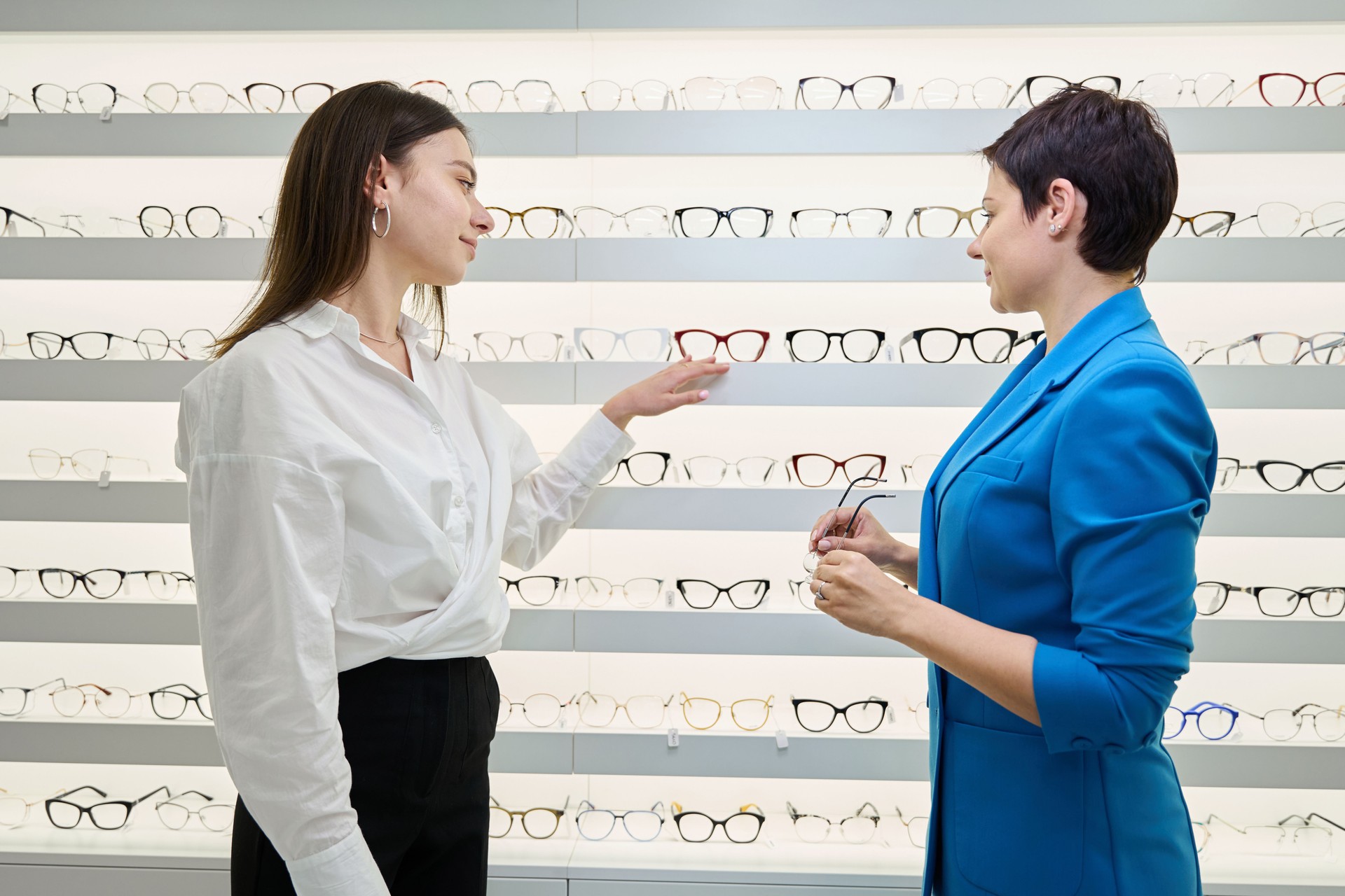 Optical dispenser showing assortment of glasses to client
